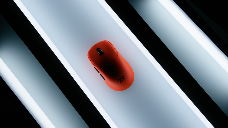 Top-down view of an orange gaming mouse between diagonal white light tubes